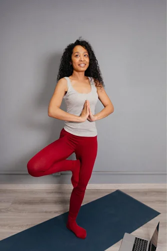 Woman in tree pose practicing yoga at home