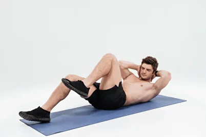 Man doing crunches on a mat